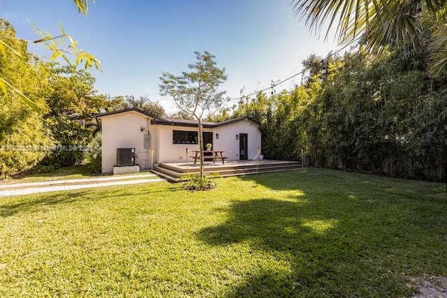 4228 NW 3rd Ave, Miami, FL 33127 - back of property with stucco siding, a lawn, and a deck