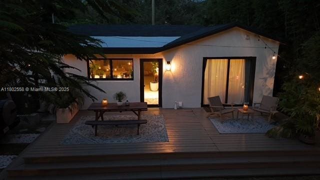 4228 NW 3rd Ave, Miami, FL 33127 - back of house with a wooden deck, an outdoor fire pit, and stucco siding