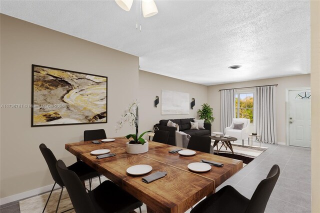 4216 NW 52nd Ave, Lauderdale Lakes, FL 33319 - dining room featuring a textured ceiling, ceiling fan, light tile patterned floors, and baseboards