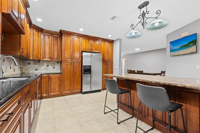 2426 NW 91st Ave, Coral Springs, FL 33065 - kitchen with stainless steel appliances, a sink, brown cabinetry, dark stone counters, and recessed lighting