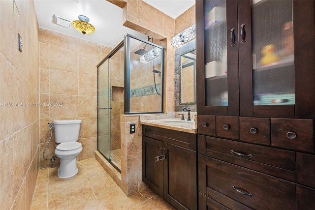 2426 NW 91st Ave, Coral Springs, FL 33065 - bathroom featuring tile walls, a stall shower, tile patterned flooring, toilet, and vanity