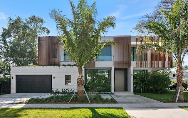 modern home featuring a balcony, concrete driveway, and a garage