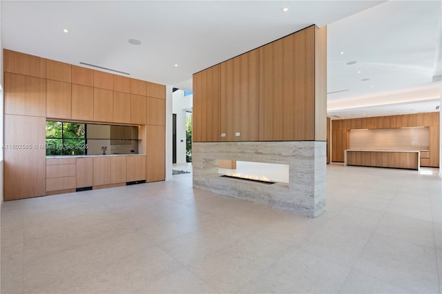 unfurnished living room featuring a multi sided fireplace and recessed lighting
