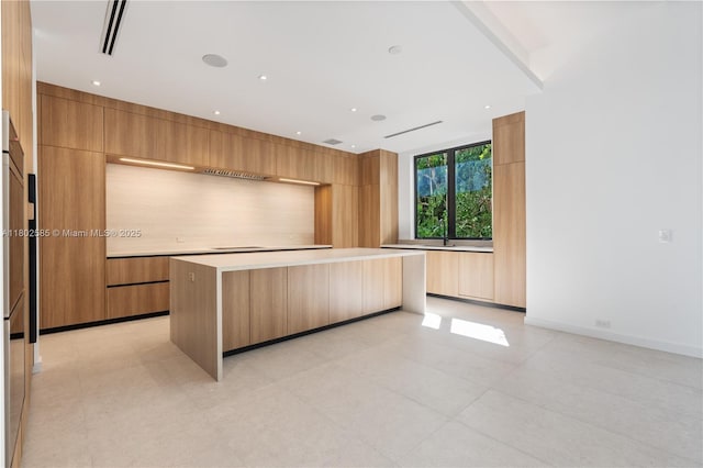 kitchen with modern cabinets, a kitchen island, and light countertops