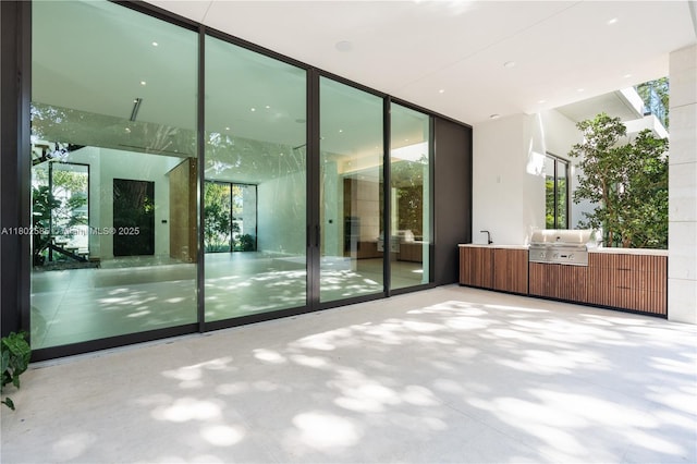 spare room featuring healthy amount of natural light, a wall of windows, and a sink