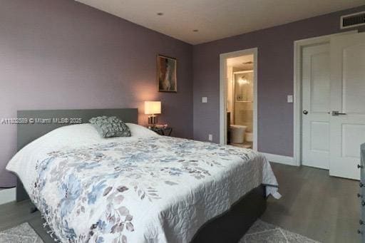 581 Blue Heron Dr Unit 318-B, Hallandale Beach, FL 33009 - bedroom with wood finished floors, baseboards, and connected bathroom