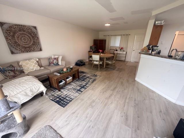 3437 NW 44th St Unit 101, Oakland Park, FL 33309 - living area featuring light wood-style flooring and baseboards
