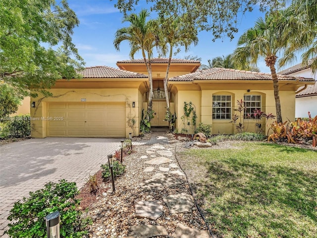 3230 SW 194th Ter, Miramar, FL 33029 - mediterranean / spanish home featuring decorative driveway, an attached garage, a tiled roof, stucco siding, and a front lawn