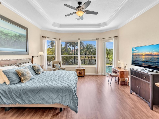 3230 SW 194th Ter, Miramar, FL 33029 - bedroom featuring a tray ceiling, light wood-style floors, access to outside, multiple windows, and crown molding