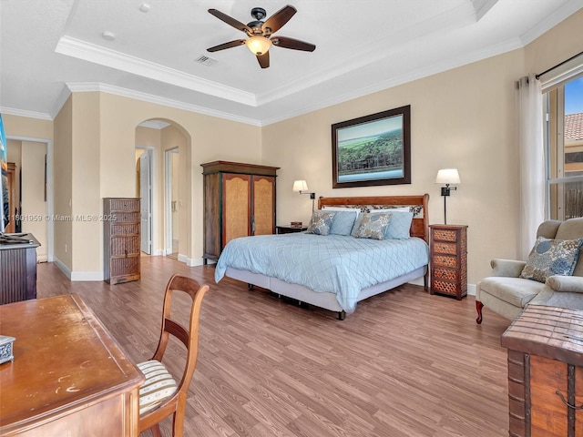 3230 SW 194th Ter, Miramar, FL 33029 - bedroom featuring a tray ceiling, arched walkways, wood finished floors, crown molding, and a ceiling fan
