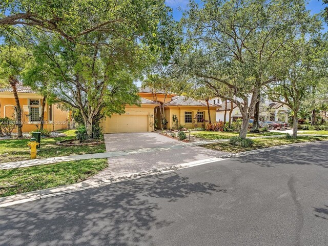 3230 SW 194th Ter, Miramar, FL 33029 - view of front of house with decorative driveway, stucco siding, an attached garage, and a tile roof