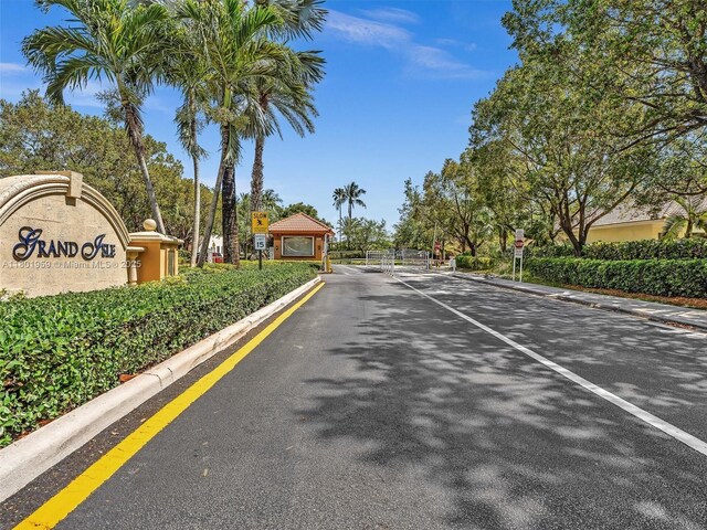 3230 SW 194th Ter, Miramar, FL 33029 - view of asphalt road featuring curbs, traffic signs, a gated entry, and a gate