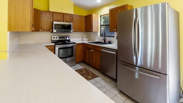 17254 N 32nd Ln N, Loxahatchee, FL 33470 - kitchen featuring stainless steel appliances, a sink, light countertops, brown cabinetry, and light tile patterned floors