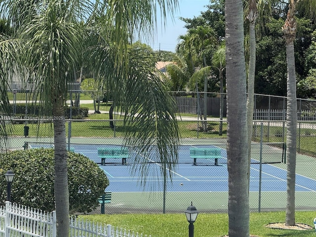 view of tennis court featuring fence