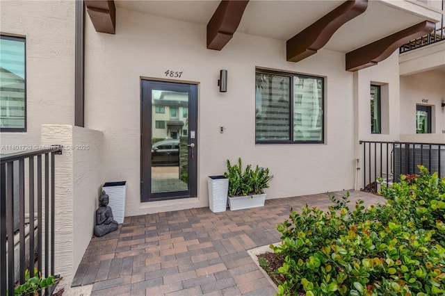 view of exterior entry featuring stucco siding