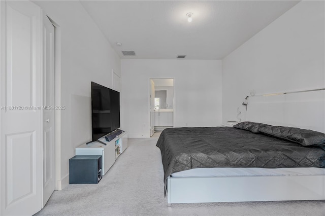bedroom with light colored carpet, ensuite bathroom, and baseboards