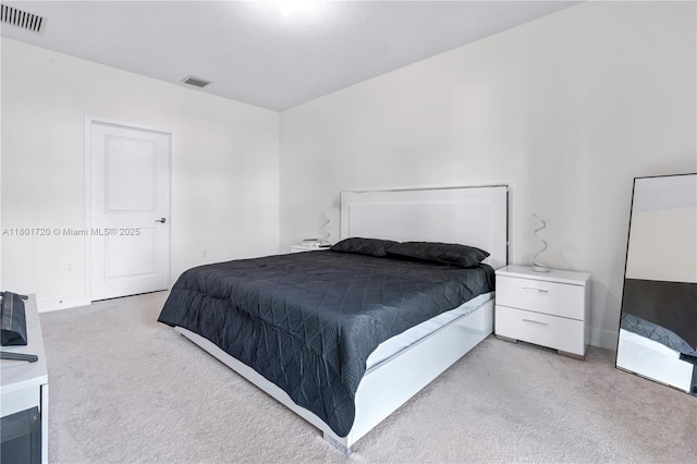 bedroom with light colored carpet and baseboards