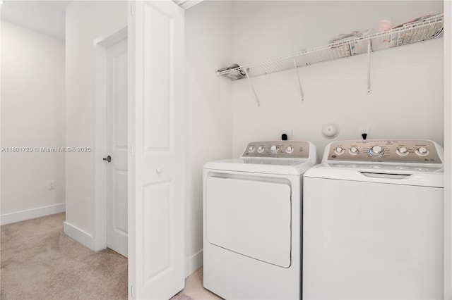 clothes washing area with separate washer and dryer, light colored carpet, and baseboards