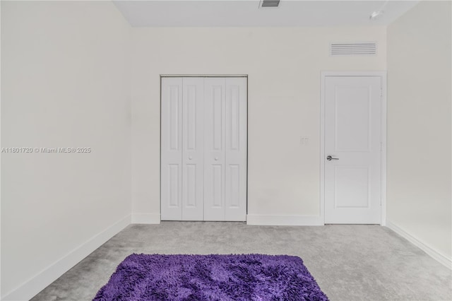 unfurnished bedroom with carpet flooring, baseboards, and a closet