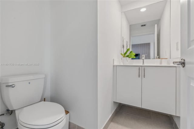 half bathroom with vanity, toilet, tile patterned flooring, baseboards, and recessed lighting