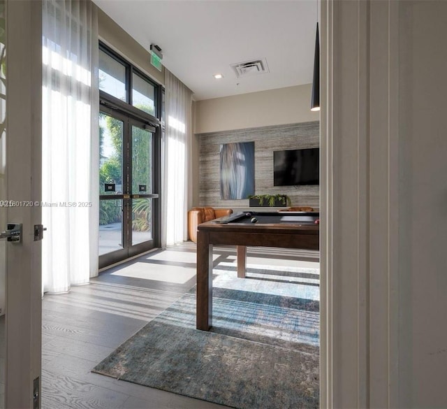 corridor with french doors, wood finished floors, and recessed lighting