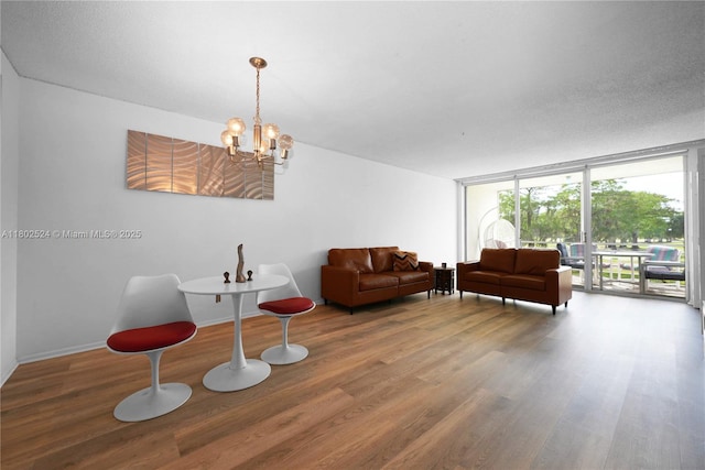 605 Oaks Dr Unit 203, Pompano Beach, FL 33069 - living room featuring wood finished floors, a chandelier, floor to ceiling windows, and baseboards