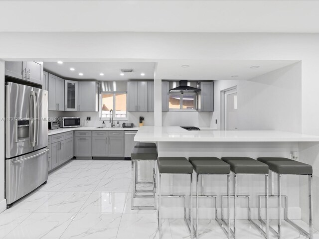 6820 SW 9th St, Pembroke Pines, FL 33023 - kitchen with appliances with stainless steel finishes, gray cabinetry, a breakfast bar area, light countertops, and glass insert cabinets