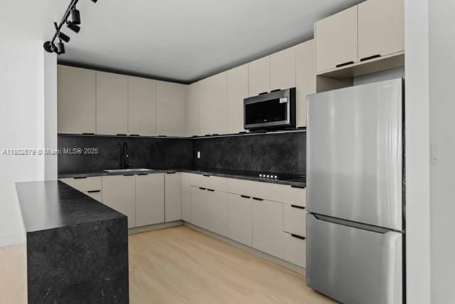 14840 Naranja Lakes Blvd Unit C4B, Homestead, FL 33032 - kitchen featuring stainless steel appliances, a sink, dark countertops, light wood finished floors, and backsplash