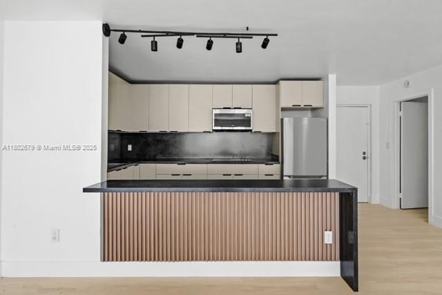 14840 Naranja Lakes Blvd Unit C4B, Homestead, FL 33032 - kitchen with appliances with stainless steel finishes, dark countertops, light wood-style flooring, backsplash, and white cabinetry