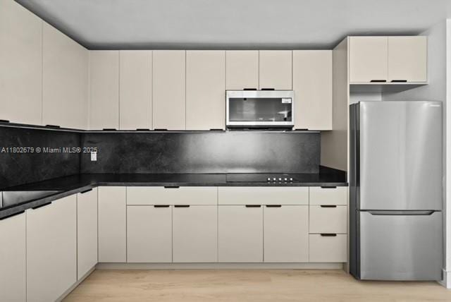 14840 Naranja Lakes Blvd Unit C4B, Homestead, FL 33032 - kitchen with appliances with stainless steel finishes, light wood finished floors, backsplash, and dark countertops