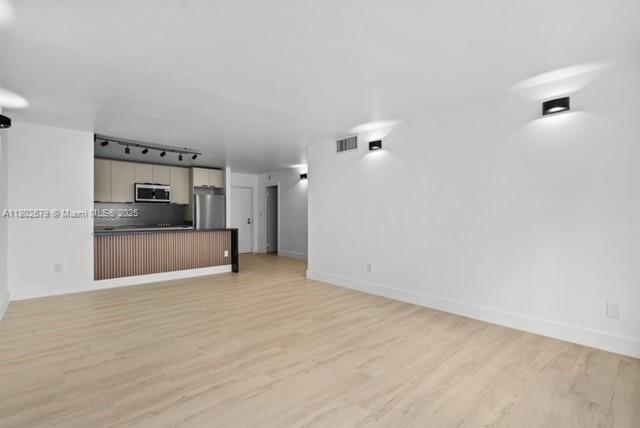 14840 Naranja Lakes Blvd Unit C4B, Homestead, FL 33032 - unfurnished living room featuring rail lighting, light wood-style flooring, and baseboards