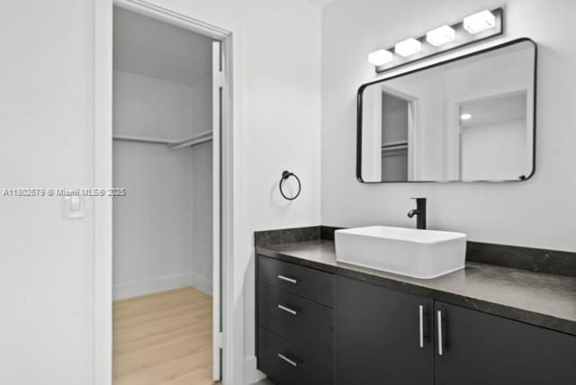 14840 Naranja Lakes Blvd Unit C4B, Homestead, FL 33032 - bathroom with wood finished floors, vanity, a walk in closet, and baseboards