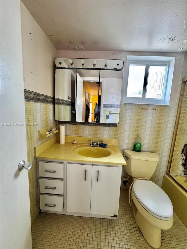 bathroom with toilet, vanity, and bathing tub / shower combination