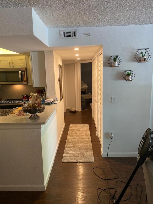 1610 NW 128th Dr Unit 104, Sunrise, FL 33323 - hallway with a textured ceiling, dark wood-type flooring, and baseboards