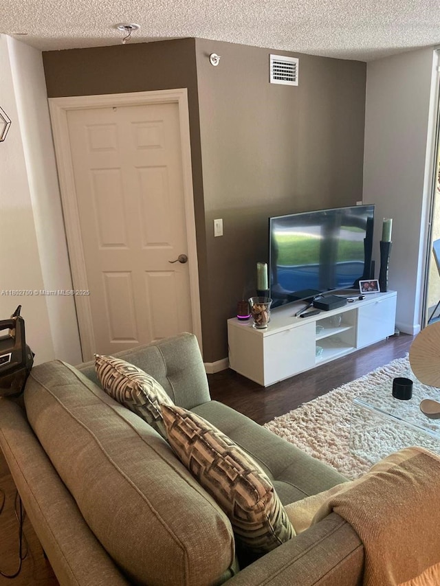 1610 NW 128th Dr Unit 104, Sunrise, FL 33323 - living area featuring a textured ceiling, wood finished floors, and baseboards