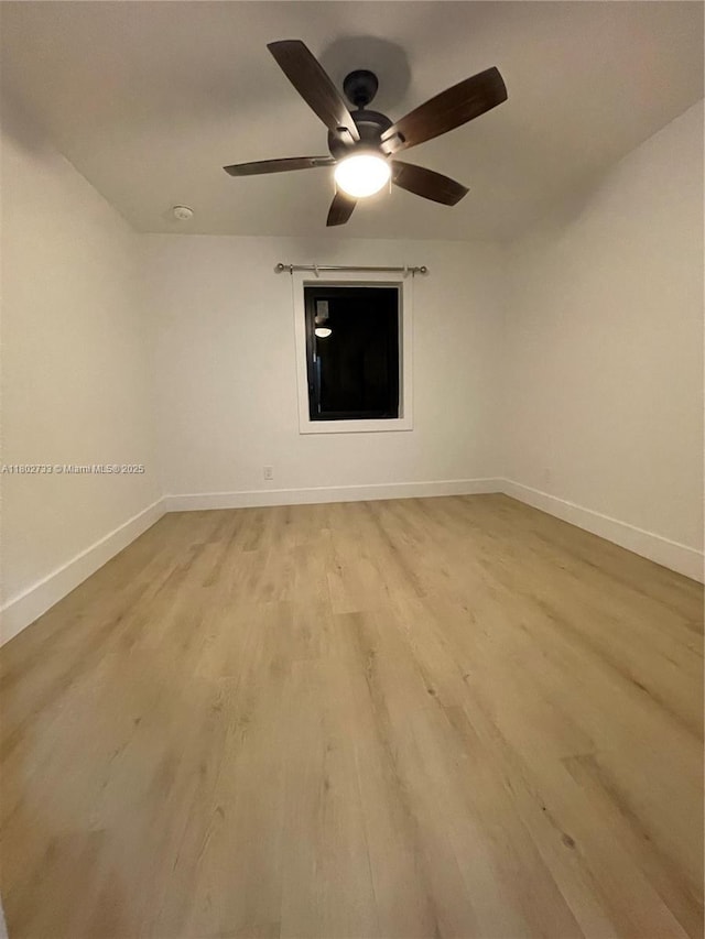 unfurnished room with ceiling fan, light wood-style floors, and baseboards