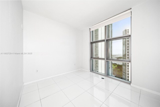 851 NE 1st Ave Unit 3107, Miami, FL 33132 - tiled empty room with baseboards and a wall of windows