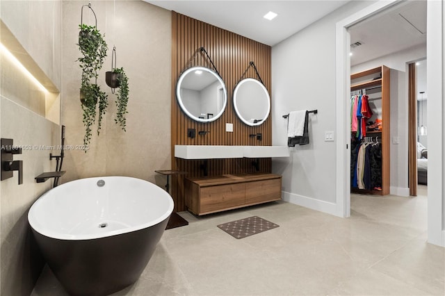 1504 Passion Vine Cir Unit 23-4, Weston, FL 33326 - bathroom with a soaking tub, vanity, a walk in closet, and baseboards