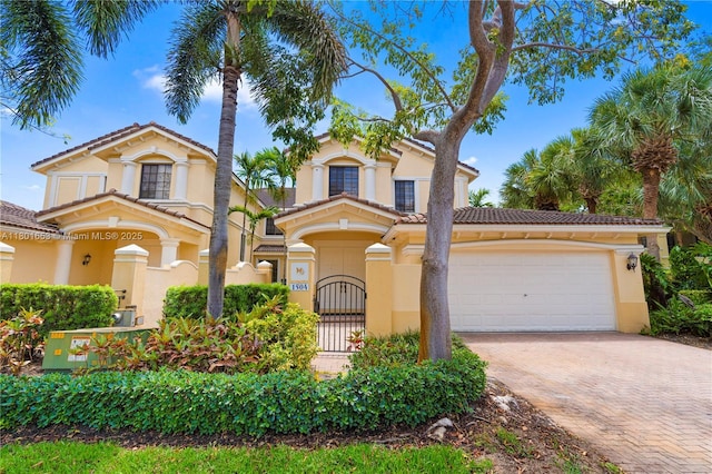 1504 Passion Vine Cir Unit 23-4, Weston, FL 33326 - mediterranean / spanish-style home featuring decorative driveway, stucco siding, an attached garage, and a tile roof