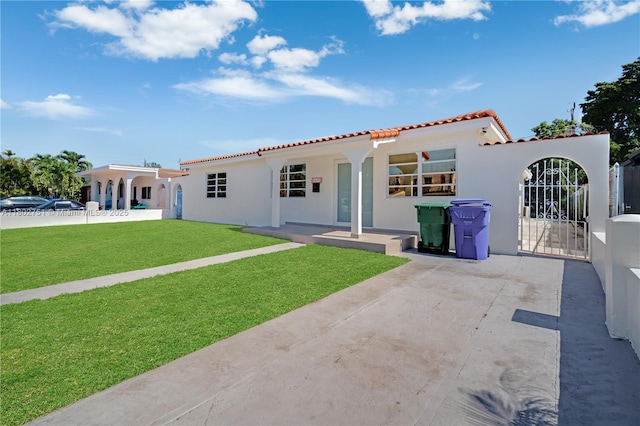 6830 SW 1st St, Miami, FL 33144 - view of front of house featuring stucco siding, a tiled roof, a front lawn, and a patio area
