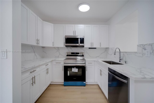 6830 SW 1st St, Miami, FL 33144 - kitchen with appliances with stainless steel finishes, a sink, white cabinetry, and backsplash