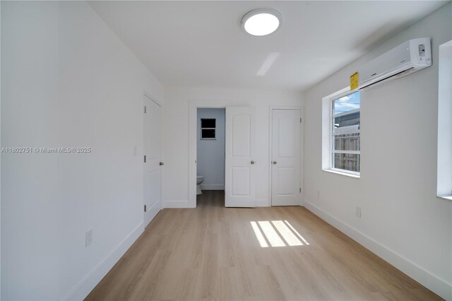 6830 SW 1st St, Miami, FL 33144 - unfurnished bedroom featuring a wall unit AC, light wood finished floors, and baseboards