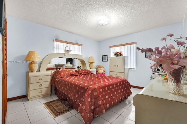 330 SW 133rd Ct, Miami, FL 33184 - bedroom with multiple windows, a textured ceiling, light tile patterned floors, and baseboards