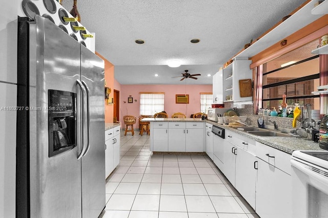 330 SW 133rd Ct, Miami, FL 33184 - kitchen featuring white appliances, a textured ceiling, a peninsula, a sink, and white cabinets