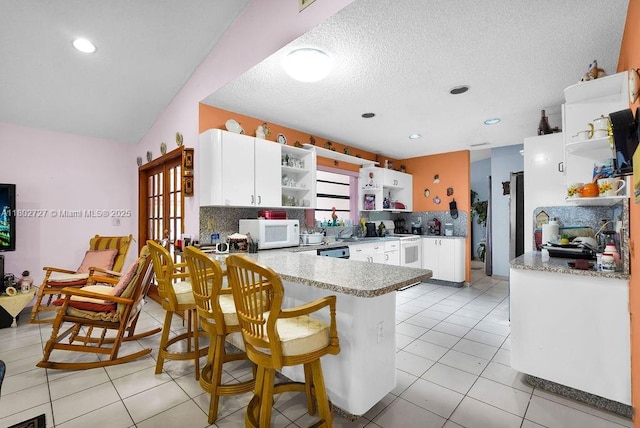 330 SW 133rd Ct, Miami, FL 33184 - kitchen with open shelves, white appliances, a peninsula, white cabinets, and light tile patterned flooring