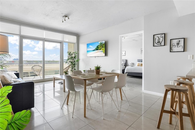 3250 NE 1st Ave Unit 706, Miami, FL 33137 - dining space with expansive windows, light tile patterned flooring, and a textured ceiling