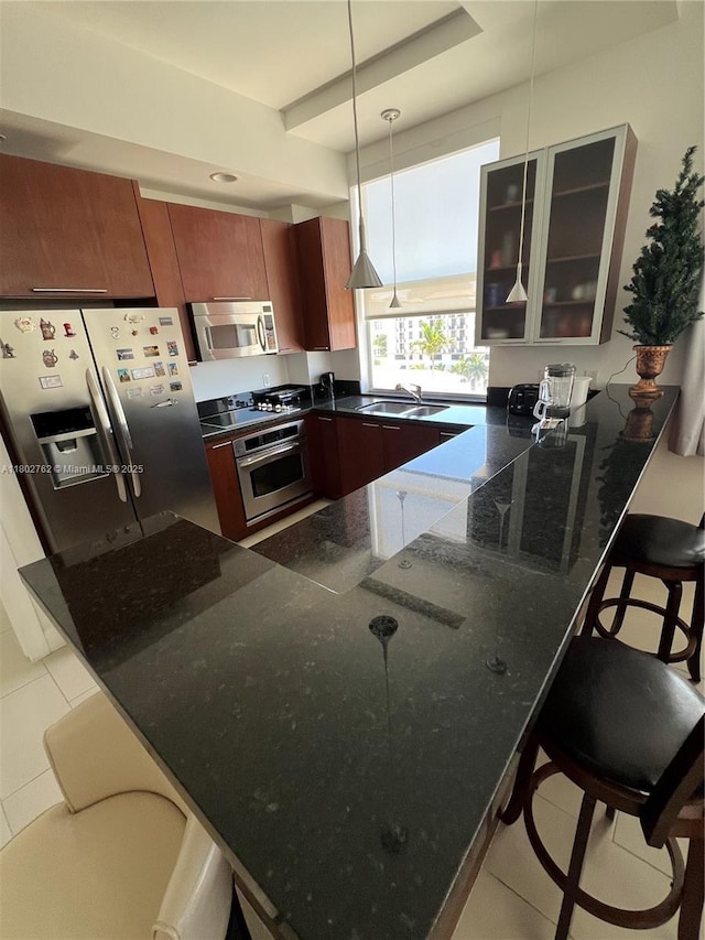 1607 Ponce De Leon Blvd Unit 8B, Coral Gables, FL 33134 - kitchen featuring appliances with stainless steel finishes, a peninsula, a kitchen bar, glass insert cabinets, and a sink