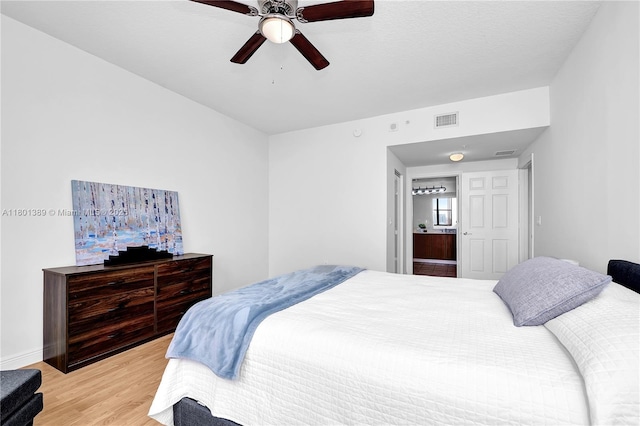 bedroom featuring light wood-style floors, a ceiling fan, and baseboards