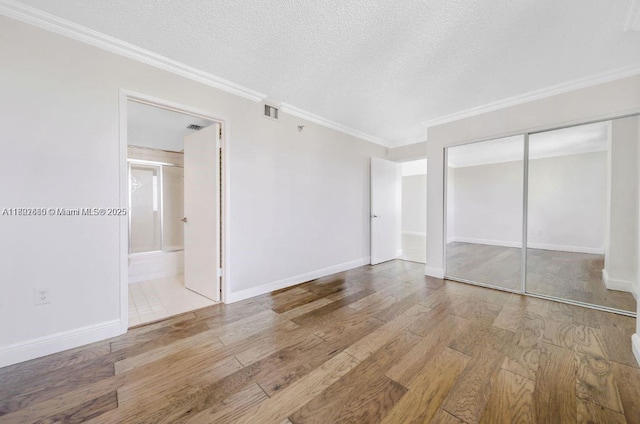 800 N Miami Ave Unit E-1709, Miami, FL 33136 - unfurnished bedroom with wood finished floors, a textured ceiling, a closet, ornamental molding, and ensuite bath