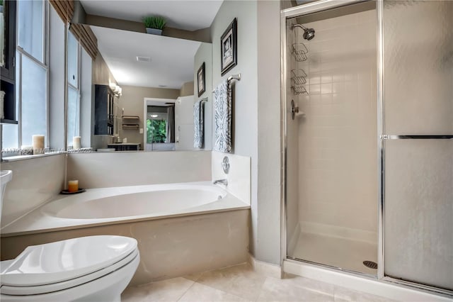 bathroom featuring a shower stall, toilet, tile patterned flooring, a garden tub, and plenty of natural light